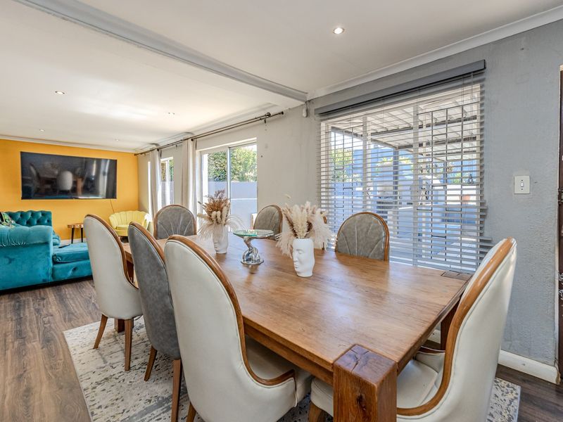 Open-plan living and dining area featuring laminate flooring, recessed lighting, and large sliding doors providing access to the outdoor space.