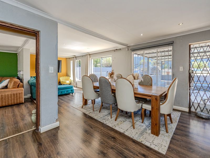 Open plan dining area featuring laminate flooring, recessed lighting, and direct access to the exterior through sliding glass doors with security gate.