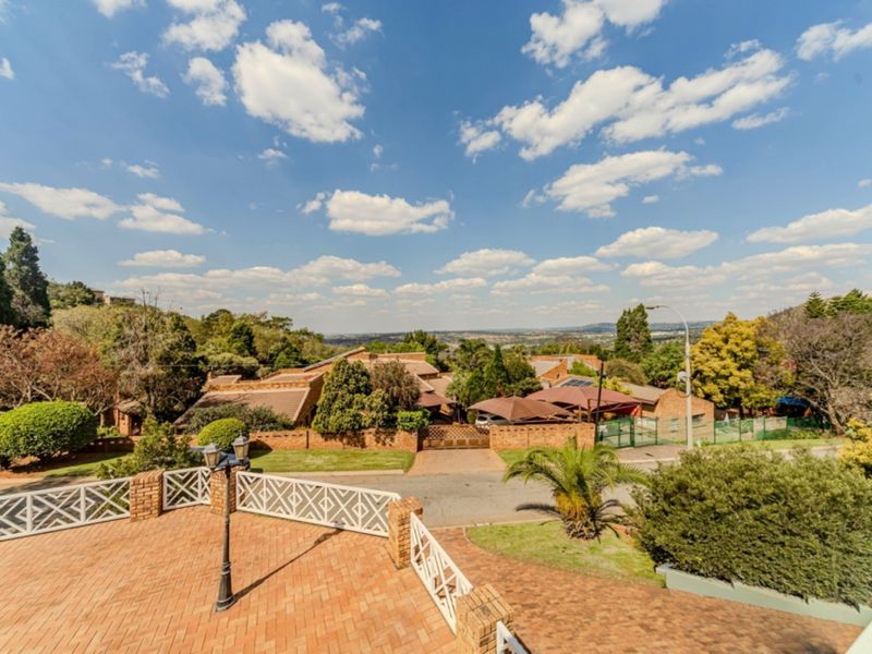 Elevated view overlooking the surrounding residential neighbourhood and landscape from a brick-paved terrace with decorative metal railings.
