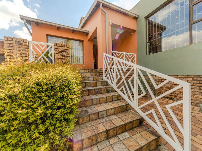 Front entrance featuring a tiled staircase with a decorative white metal balustrade leading to the main doorway.