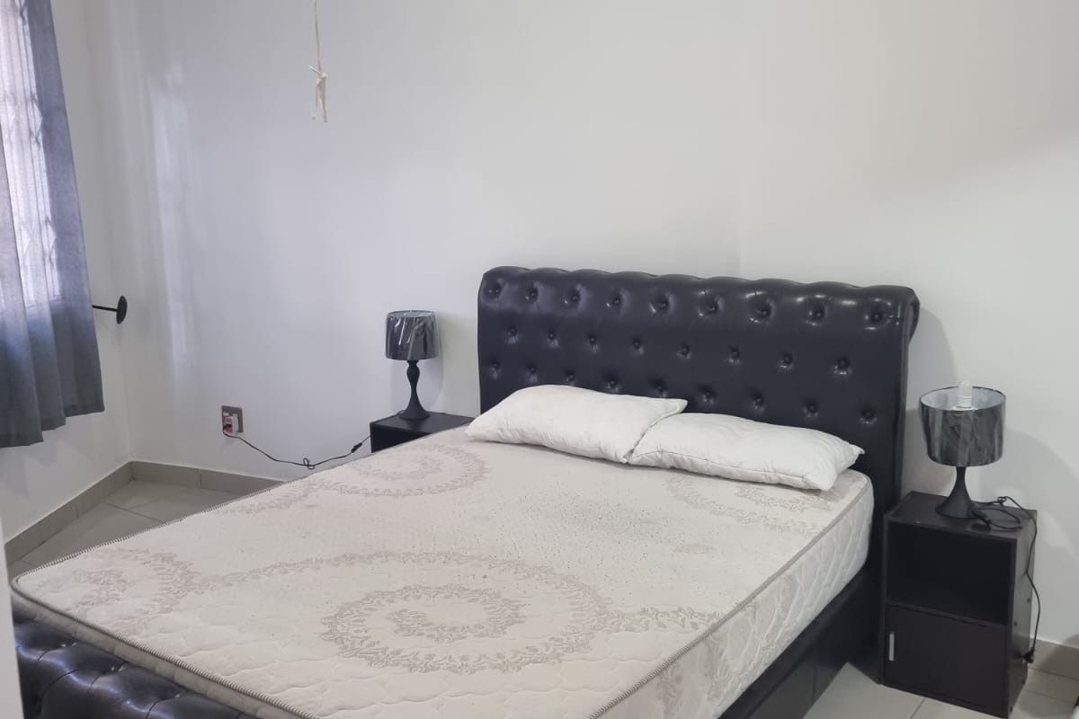 A bedroom featuring tiled flooring and a neutral wall finish, providing a clean and functional space.