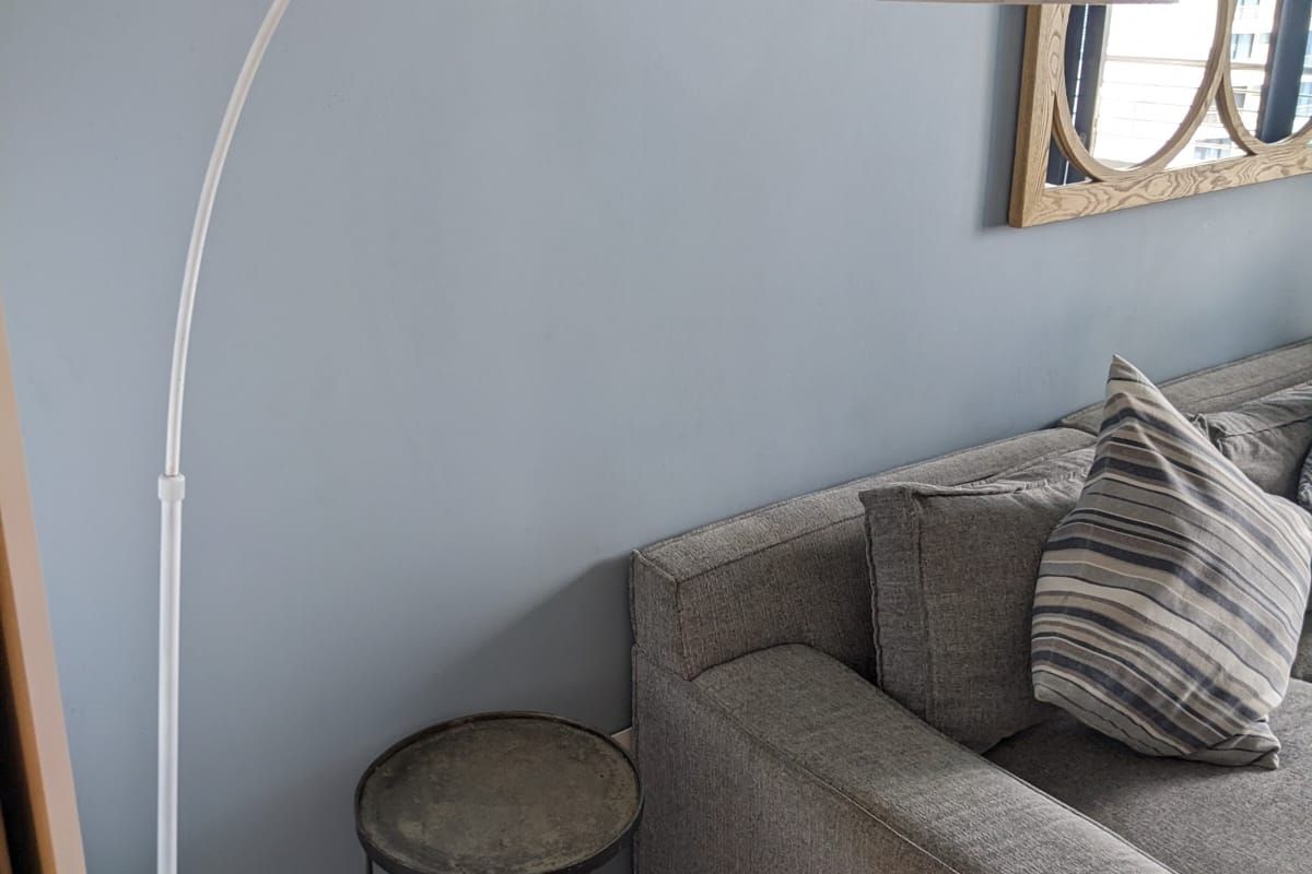 A close-up view of a living room corner featuring tiled flooring and neutral wall paint.