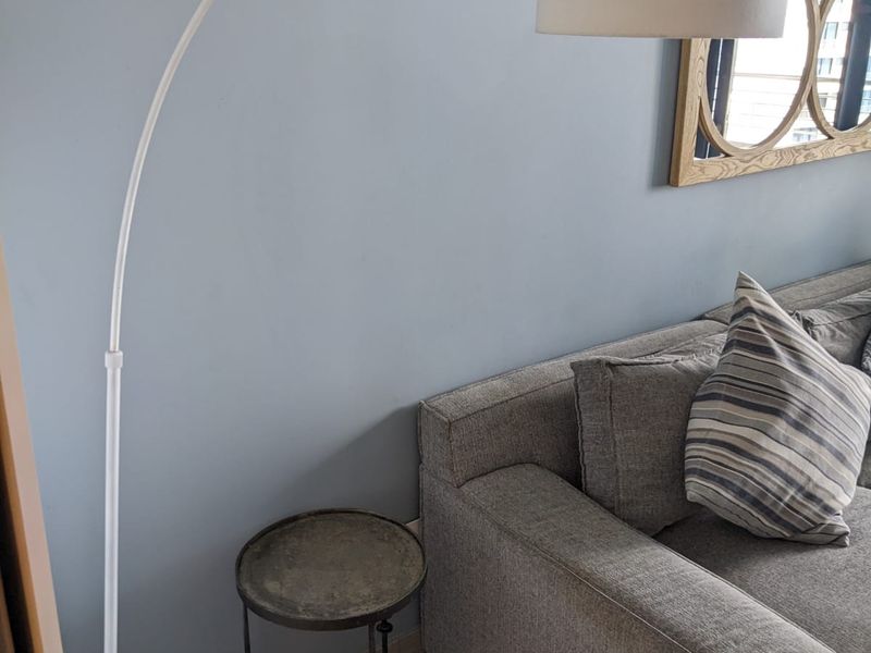 A close-up view of a living room corner featuring tiled flooring and neutral wall paint.