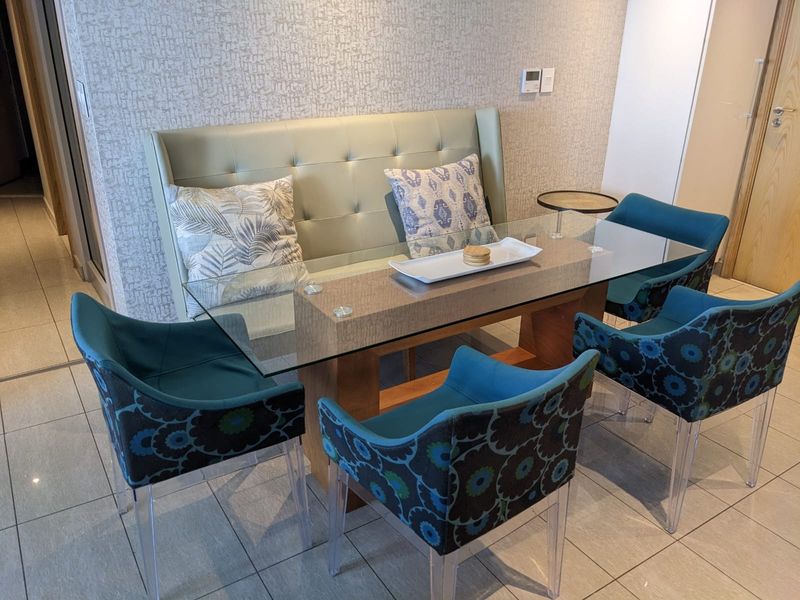A well-maintained dining area featuring modern tiled flooring and textured feature wallpaper, providing a clean and contemporary space for meals.