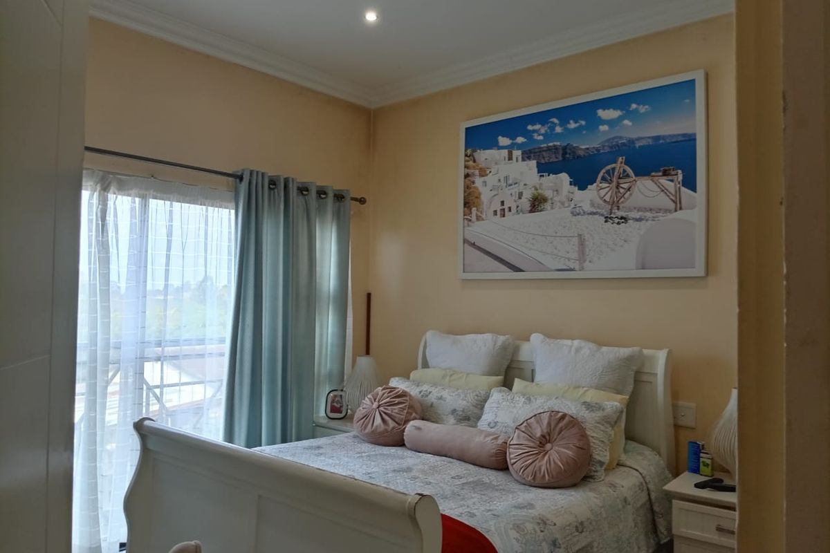 A bedroom featuring a sliding glass door with curtains, recessed downlighting, and decorative cornice detailing.