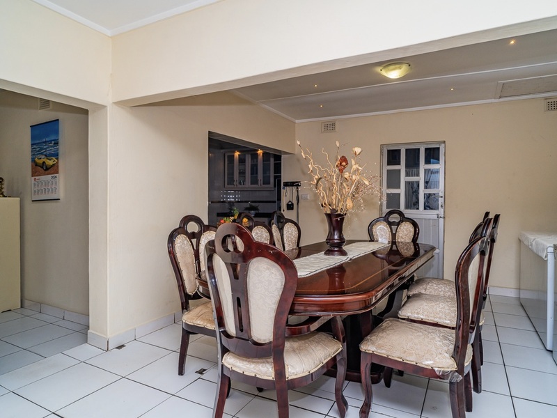 Open plan dining area featuring tiled flooring and recessed lighting, with a view into the adjacent kitchen space.