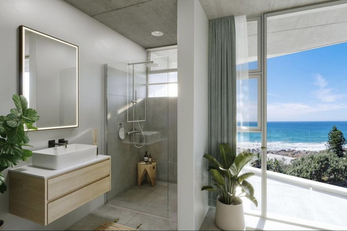 Modern bathroom featuring a floating vanity, walk-in glass shower, and floor-to-ceiling windows offering expansive ocean views.