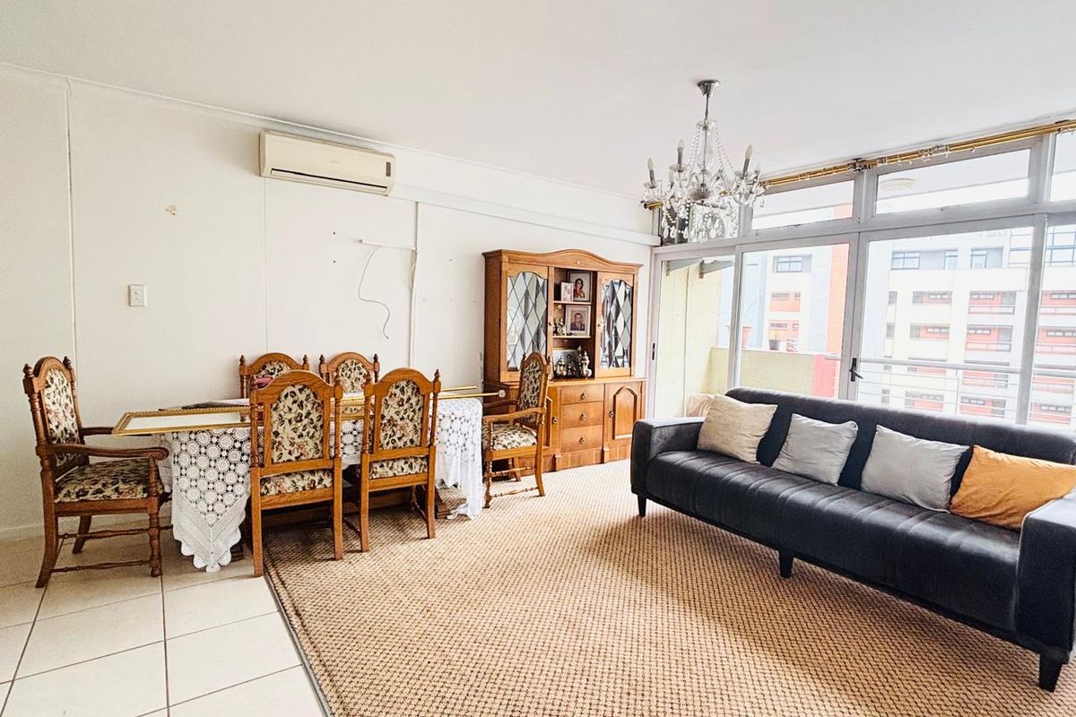 Spacious living and dining area featuring tiled floors, a split-system air conditioner, and large glass sliding doors providing ample natural light.