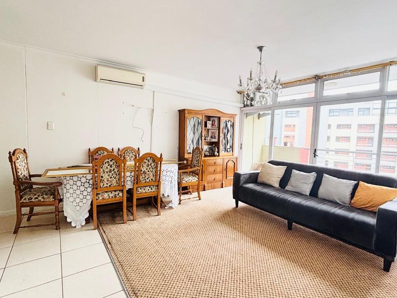 Spacious living and dining area featuring tiled floors, a split-system air conditioner, and large glass sliding doors providing ample natural light.