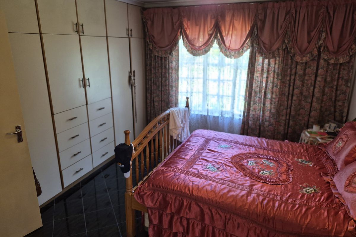 A bedroom featuring extensive built-in floor-to-ceiling cabinetry and dark tiled flooring, providing ample storage space.