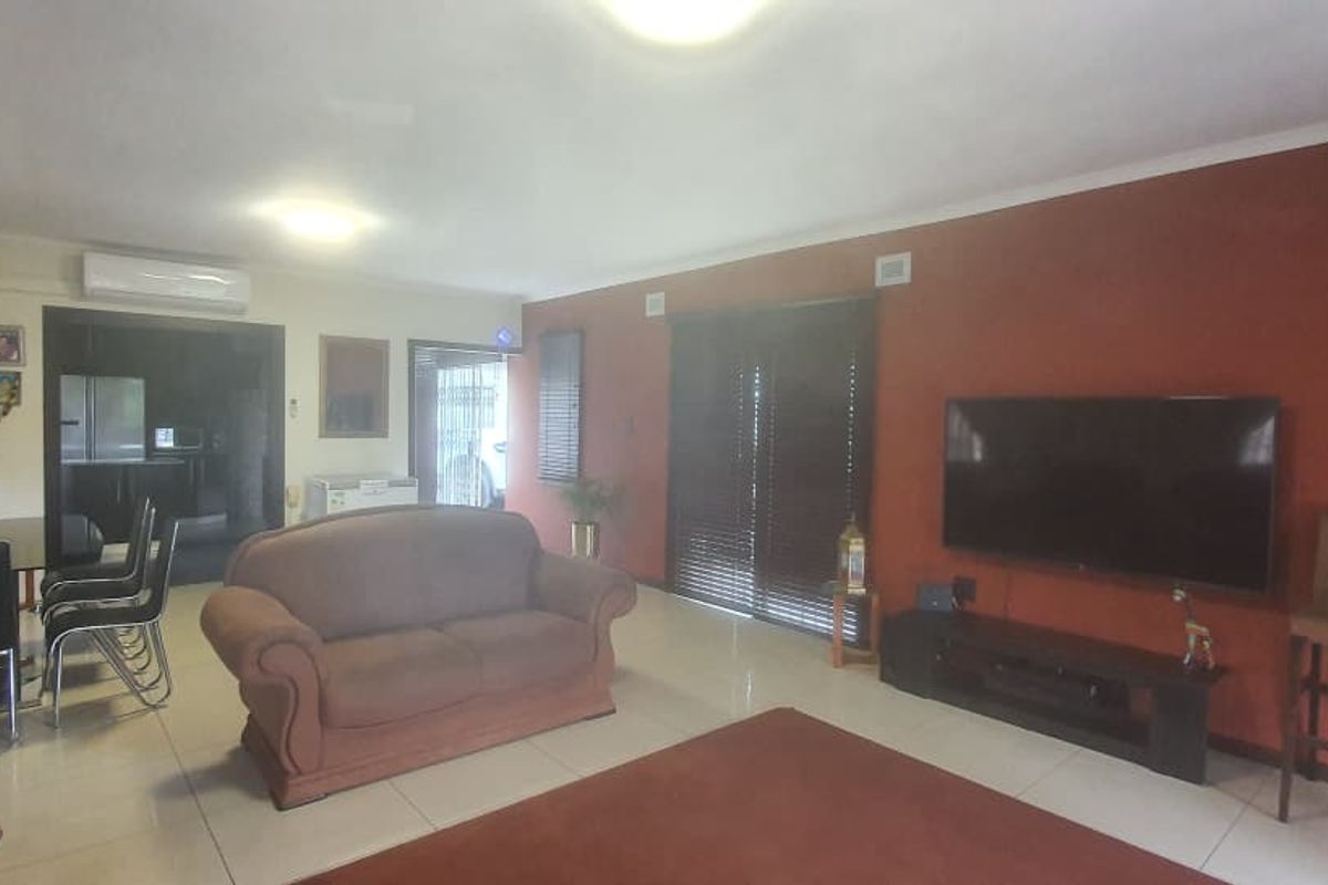 Spacious living area featuring tiled flooring, split-system air conditioning, and sliding glass doors providing access to the exterior.