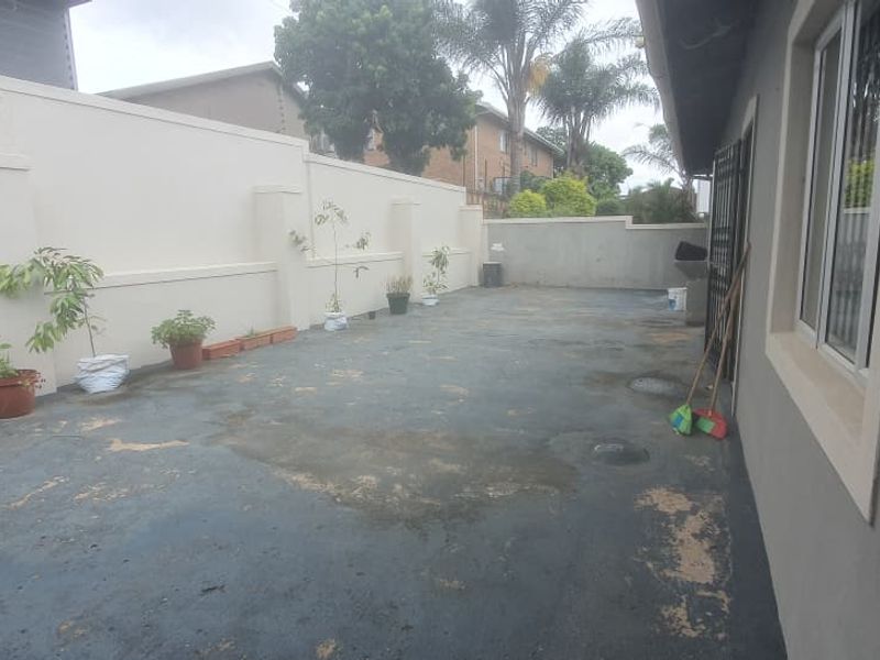 A rear courtyard area featuring a paved surface and high boundary walls, offering a private outdoor space with potential for landscaping or patio upgrades.