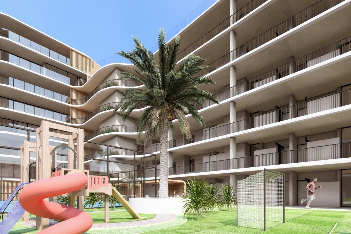 A modern apartment complex exterior featuring tiered balconies, landscaped grounds, and a communal play area with integrated structural design.