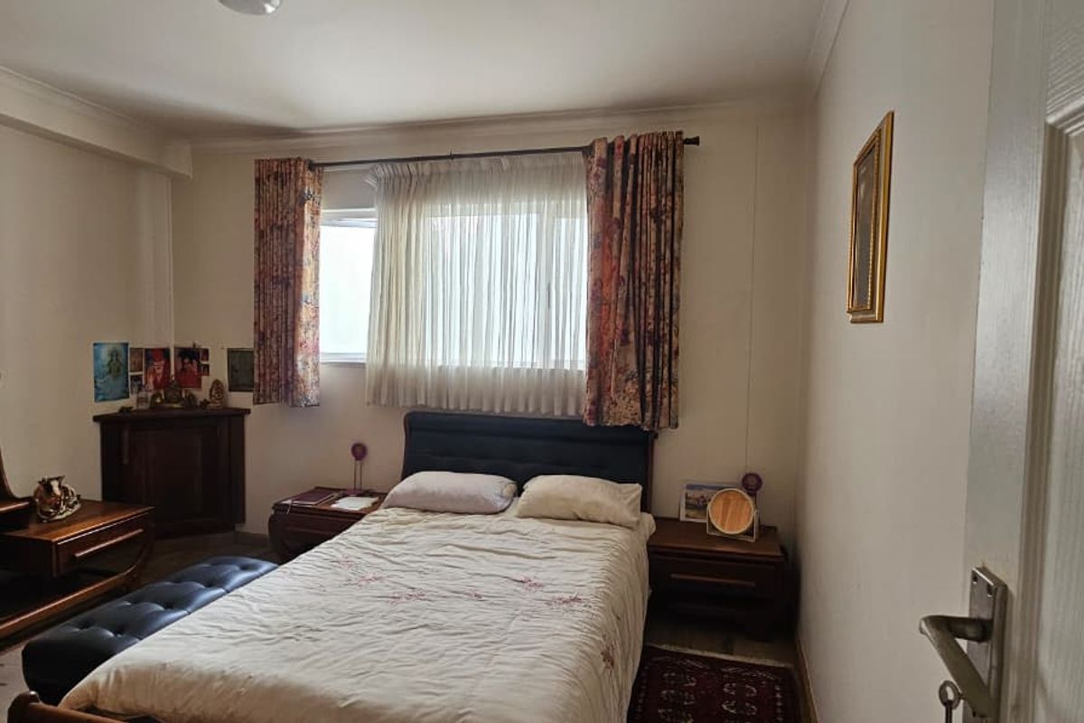 A standard bedroom featuring a window with curtain tracks and neutral wall finishes.
