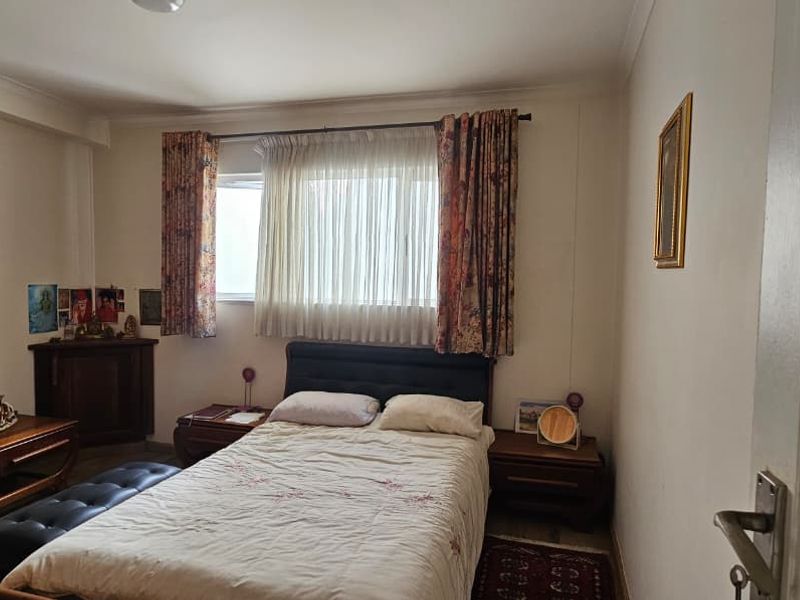 A standard bedroom featuring a window with curtain tracks and neutral wall finishes.