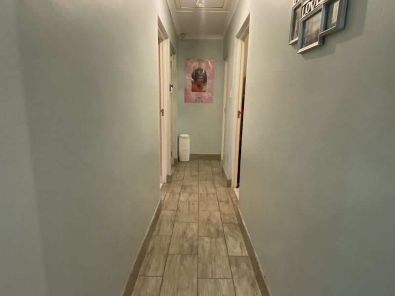 A functional interior hallway featuring tiled flooring and access to multiple rooms within the townhouse.