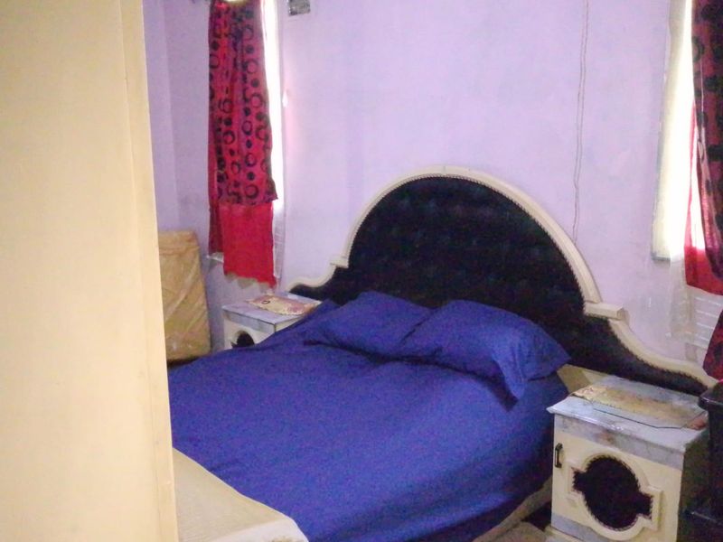 A bedroom featuring purple walls and a built-in electrical outlet, requiring cosmetic updates to improve the overall aesthetic and finish.