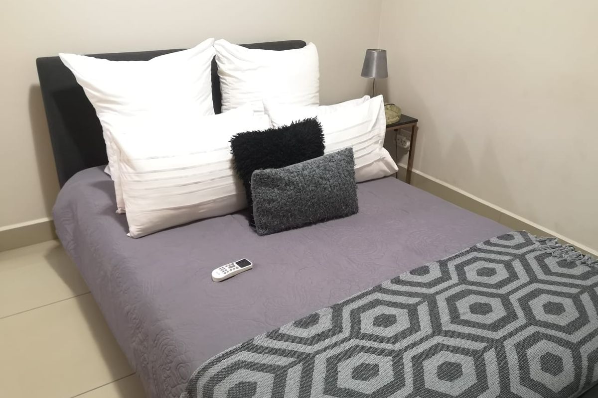 A compact bedroom featuring tiled flooring and neutral wall finishes, providing a simple and functional sleeping space.