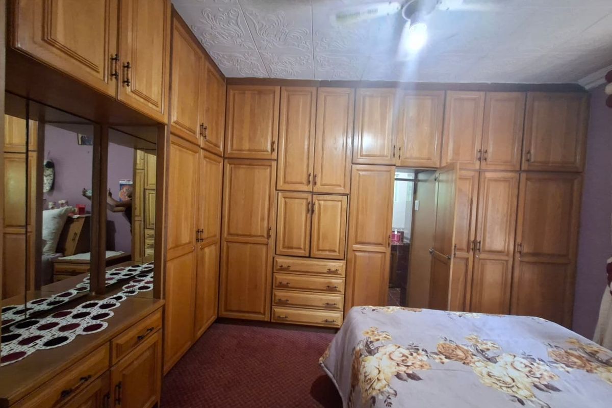Bedroom featuring extensive wall-to-wall built-in wooden cabinetry and a ceiling fan, providing ample storage space.