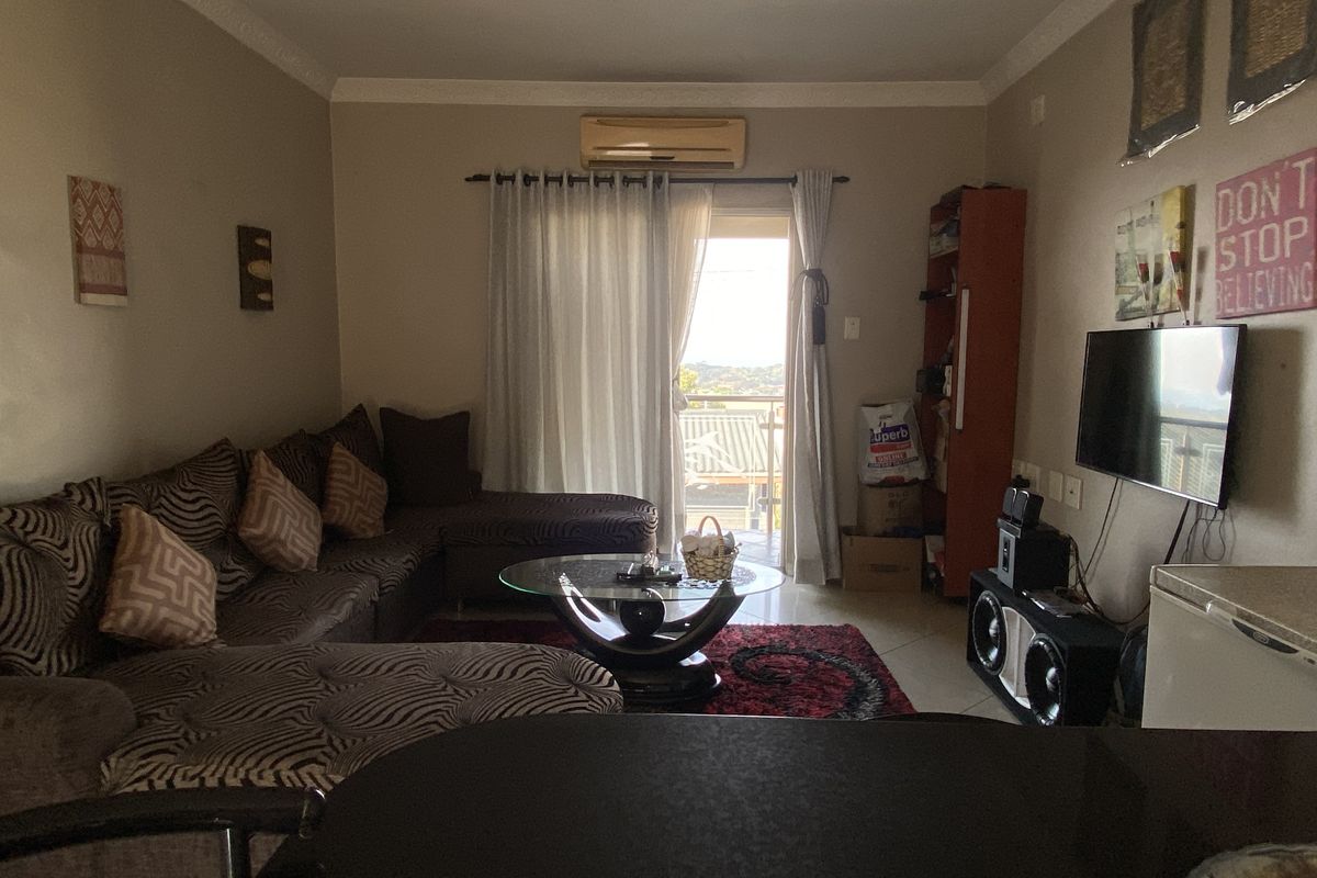 A living room featuring a split-system air conditioner, recessed downlights, and a sliding glass door providing access to an outdoor balcony area.