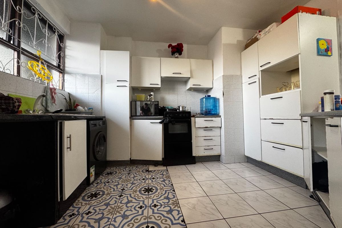 A functional kitchen featuring built-in cabinetry, tiled backsplash, and a built-in oven, offering a practical layout with potential for modern updates.