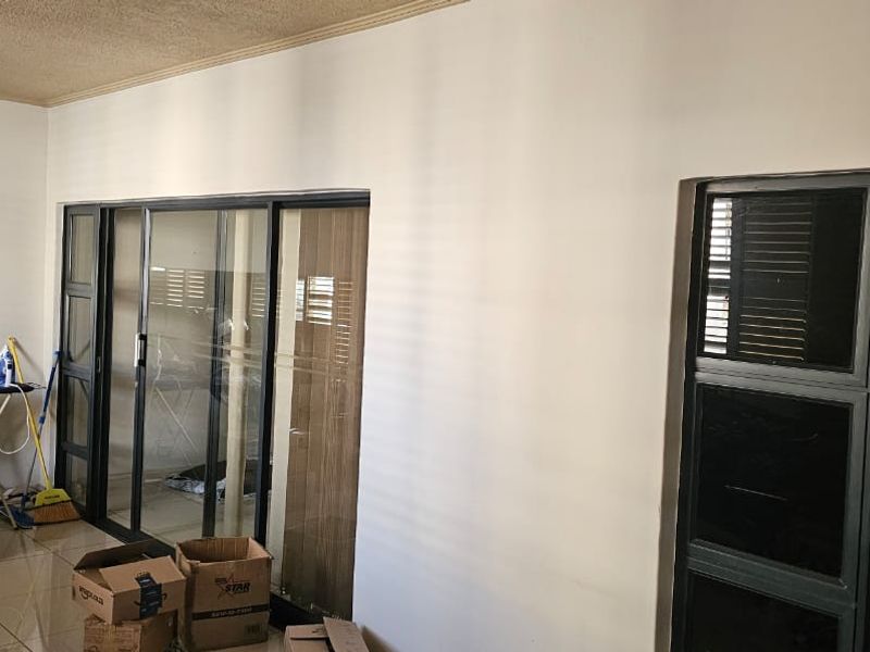 Spacious living area featuring large sliding glass doors, tiled flooring, and neutral walls, offering a bright and versatile space for modern living.