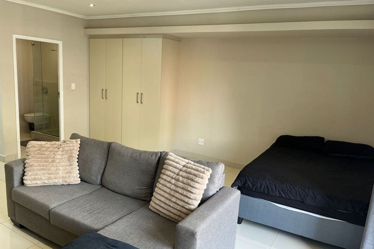 A bedroom featuring built-in cupboards, tiled flooring, recessed lighting, and direct access to an en-suite bathroom.
