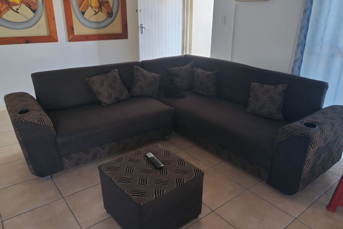 A living room area featuring ceramic floor tiles and a wall-mounted air conditioning unit.