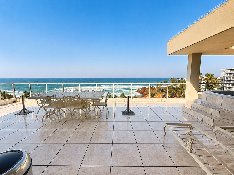 Spacious outdoor balcony featuring tiled flooring, a glass balustrade, and panoramic ocean views, providing an ideal setting for coastal living.