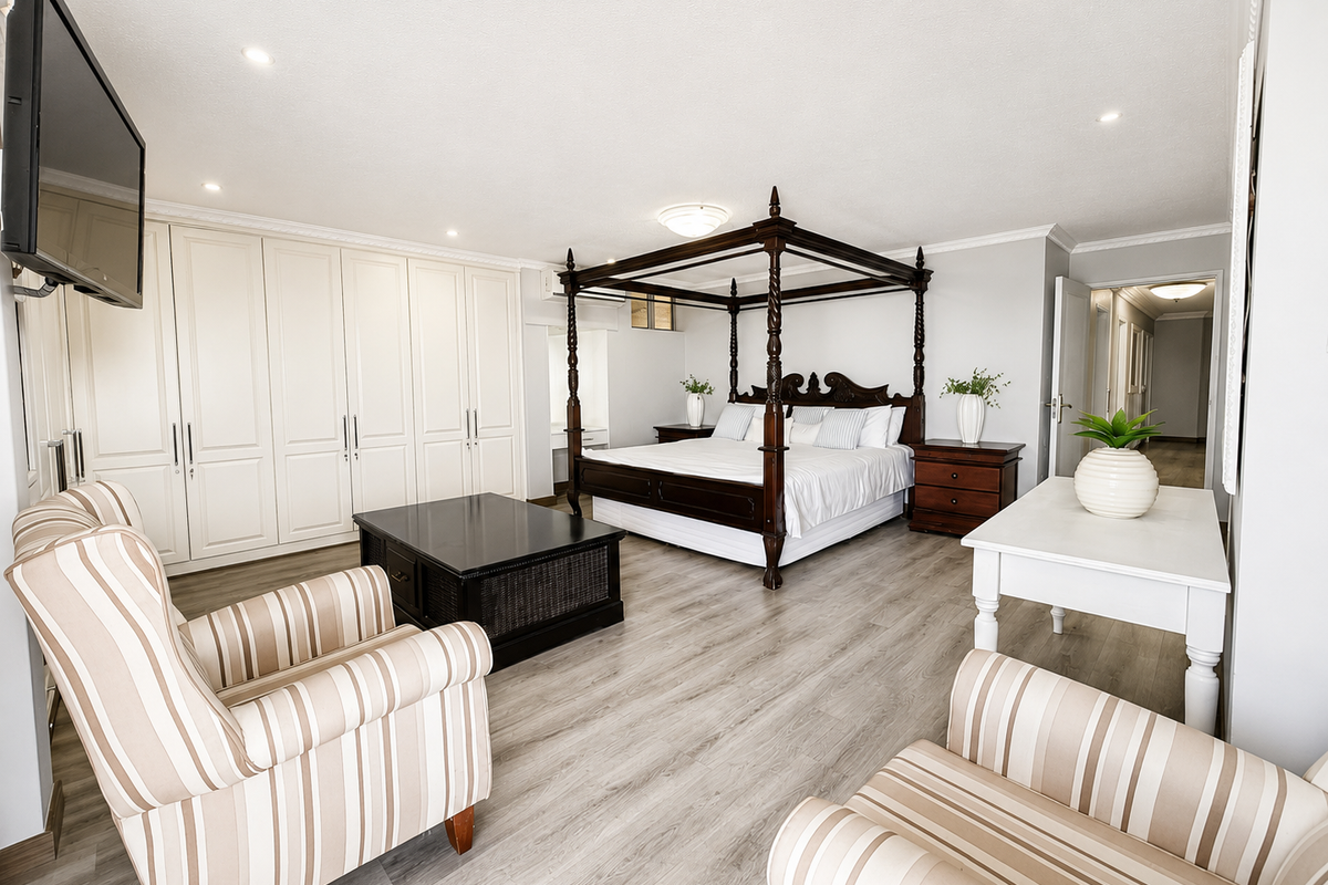 Spacious bedroom featuring extensive built-in cabinetry, modern laminate flooring, and recessed lighting, offering a clean and well-maintained living environment.