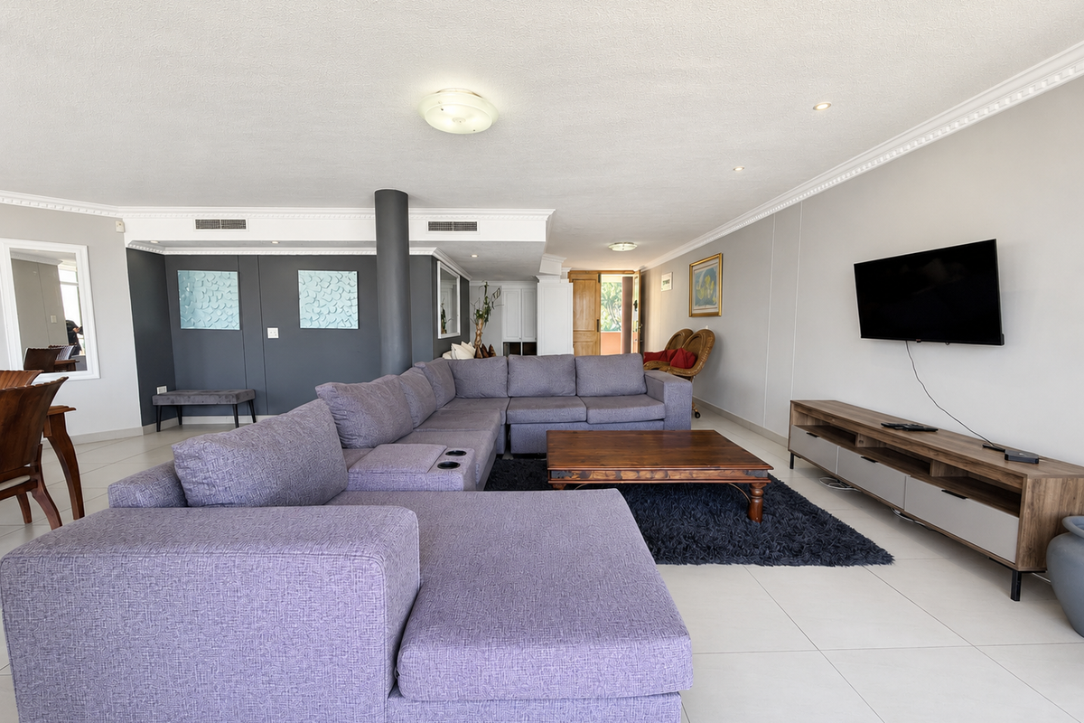 Spacious open-plan living area featuring tiled flooring, crown molding, recessed lighting, and ducted air conditioning, providing a comfortable and well-maintained living space.