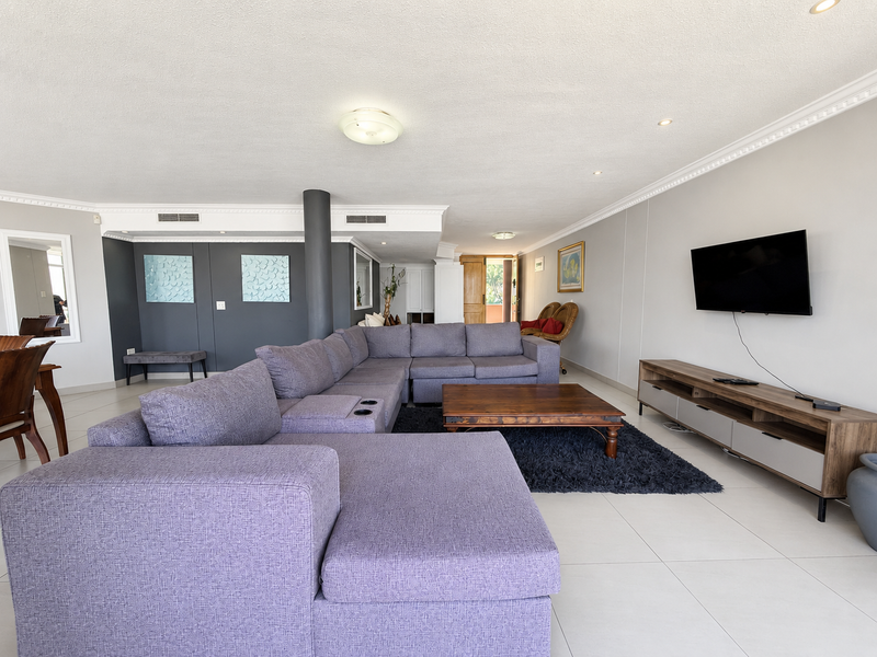 Spacious open-plan living area featuring tiled flooring, crown molding, recessed lighting, and ducted air conditioning, providing a comfortable and well-maintained living space.