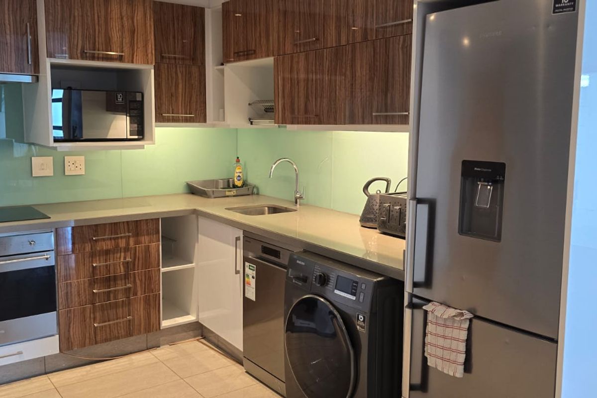 Modern kitchen featuring wood-grain cabinetry, stone countertops, glass splashback, and integrated appliances including an oven, hob, and dishwasher.