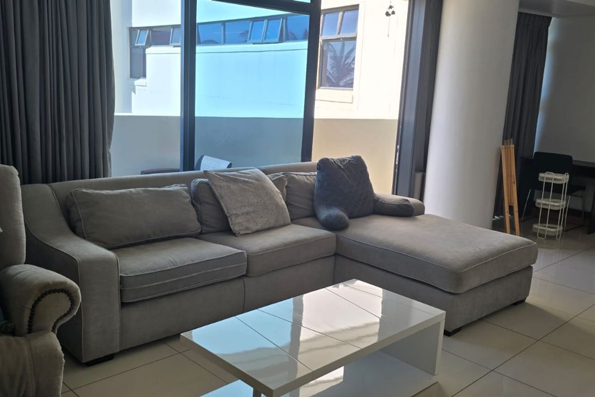 Spacious living area featuring large sliding glass doors that provide ample natural light and access to the exterior, complemented by neutral tiled flooring.