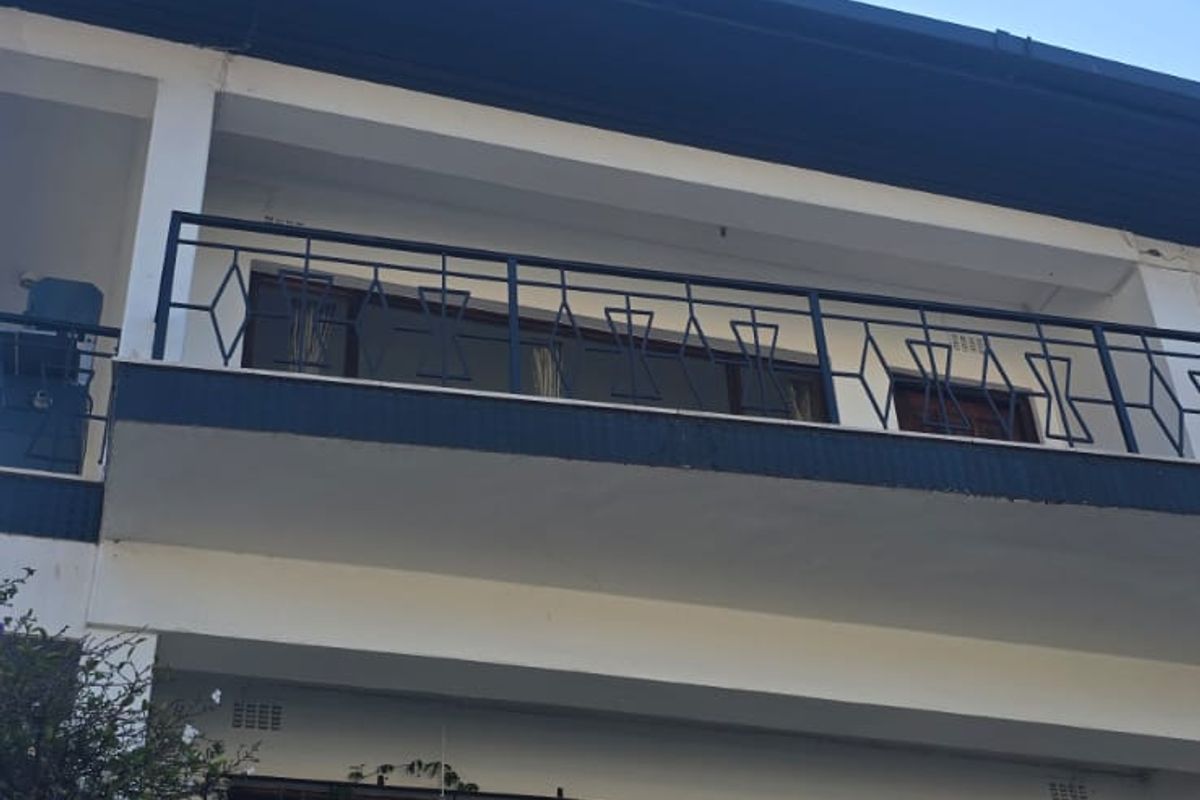 A multi-level rear exterior view of the property featuring wrought iron balcony railings and sliding glass doors with security gates.