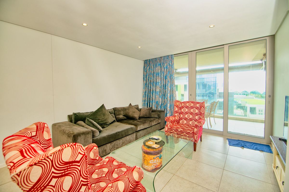 A bright living room featuring large sliding glass doors that provide natural light and access to an outdoor balcony area.