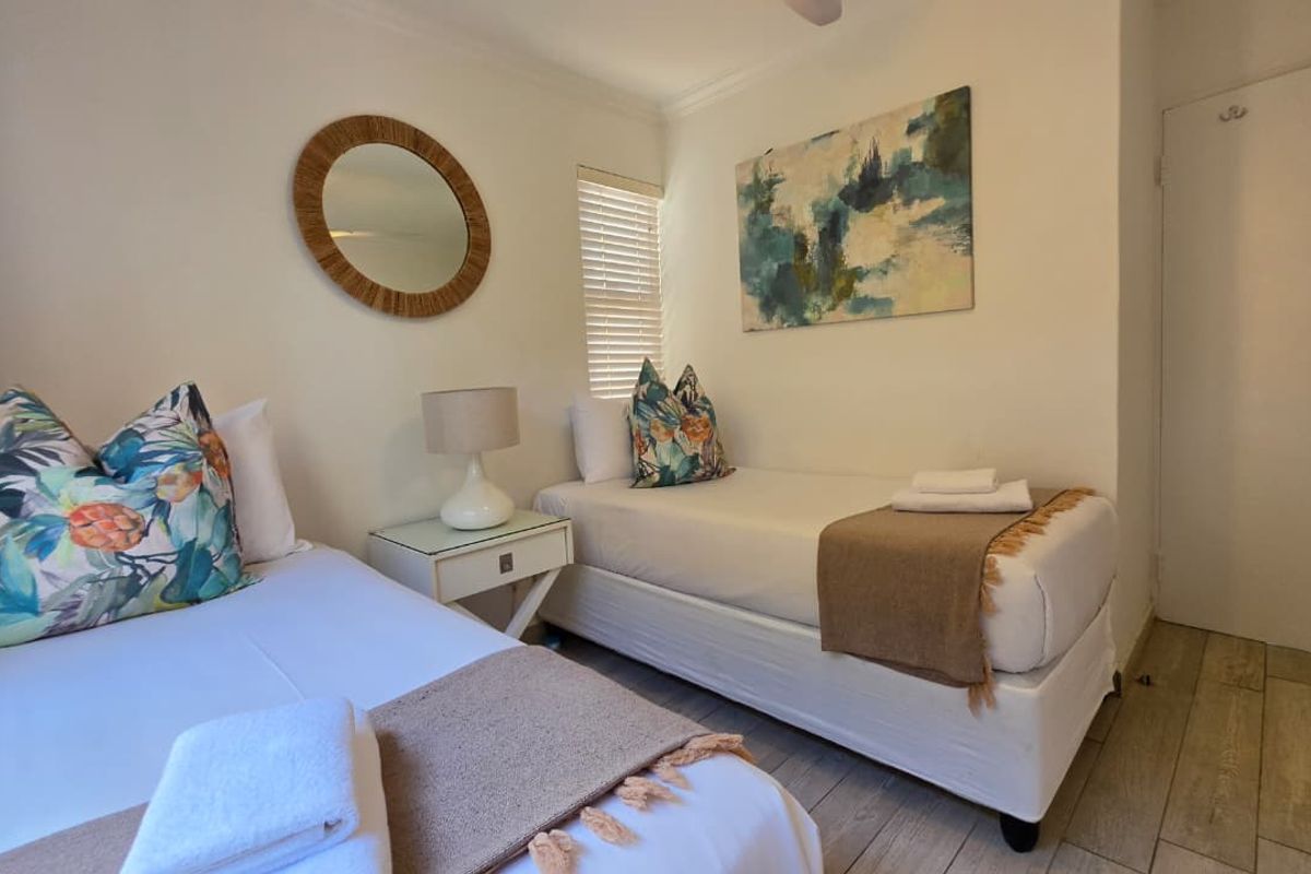 A well-maintained bedroom featuring tiled flooring, a ceiling fan, and venetian blinds, providing a comfortable and functional living space.