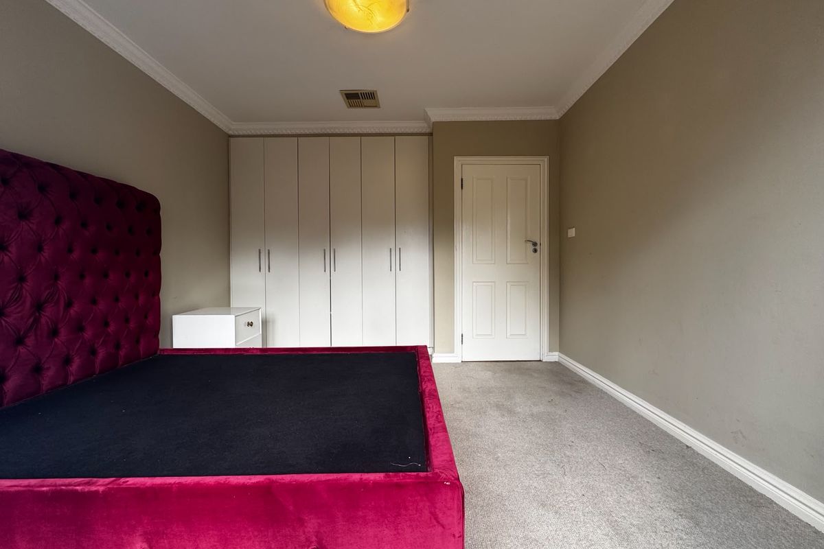 Bedroom featuring built-in wardrobes, neutral wall tones, coving, and carpet flooring.