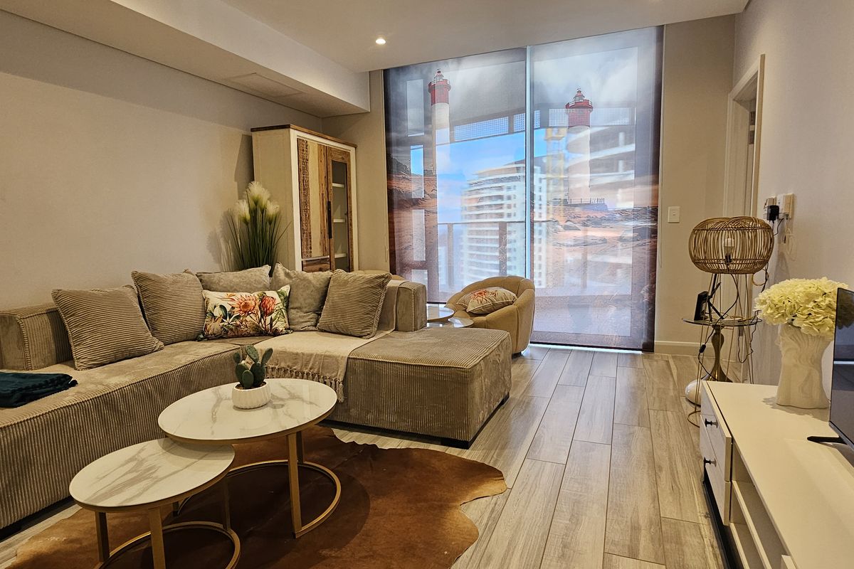 A well-maintained living room featuring wood-look tile flooring, recessed lighting, and a large window with a view, providing a bright and comfortable living space.