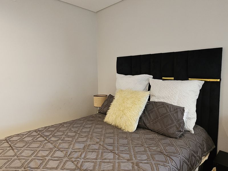 A clean and well-maintained bedroom featuring neutral wall finishes and a modern aesthetic.