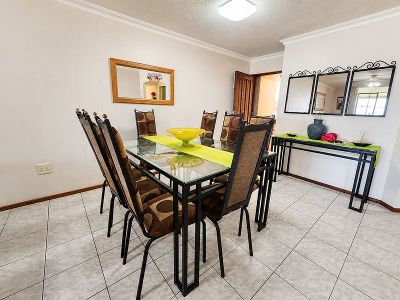 A dining room featuring tiled flooring, cove cornicing, and a central ceiling light fixture.