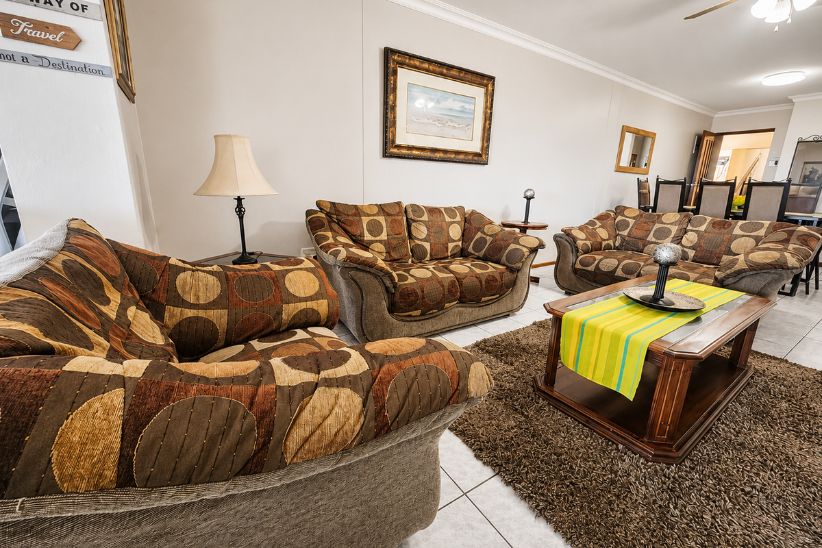 Spacious living room featuring tiled flooring, coved cornicing, and a ceiling fan, providing a comfortable and functional area for relaxation.