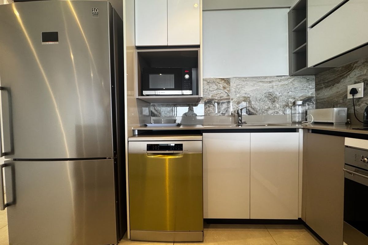 Modern kitchen featuring sleek cabinetry, stone backsplash, integrated dishwasher, built-in microwave, and oven with high-quality stainless steel finishes.