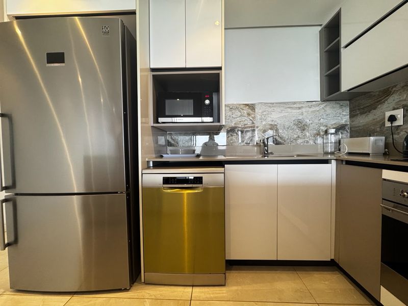 Modern kitchen featuring sleek cabinetry, stone backsplash, integrated dishwasher, built-in microwave, and oven with high-quality stainless steel finishes.