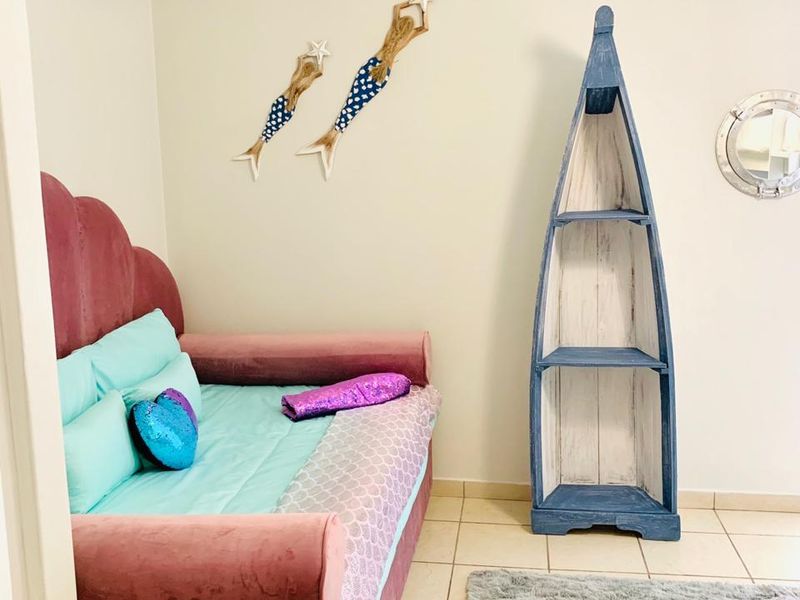 A bedroom featuring tiled flooring and neutral wall finishes, currently styled with a nautical theme.