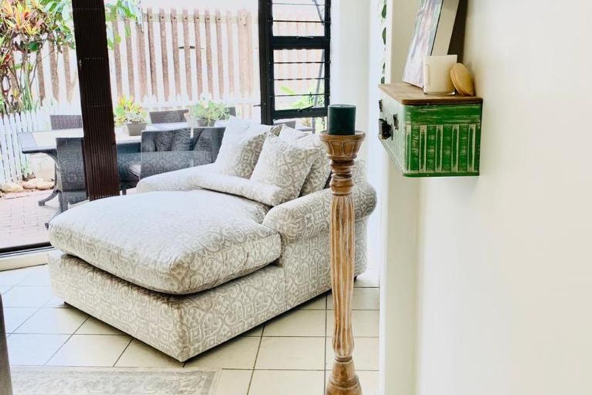 A bright living area featuring tiled flooring and large sliding glass doors that provide seamless access to the outdoor patio space.