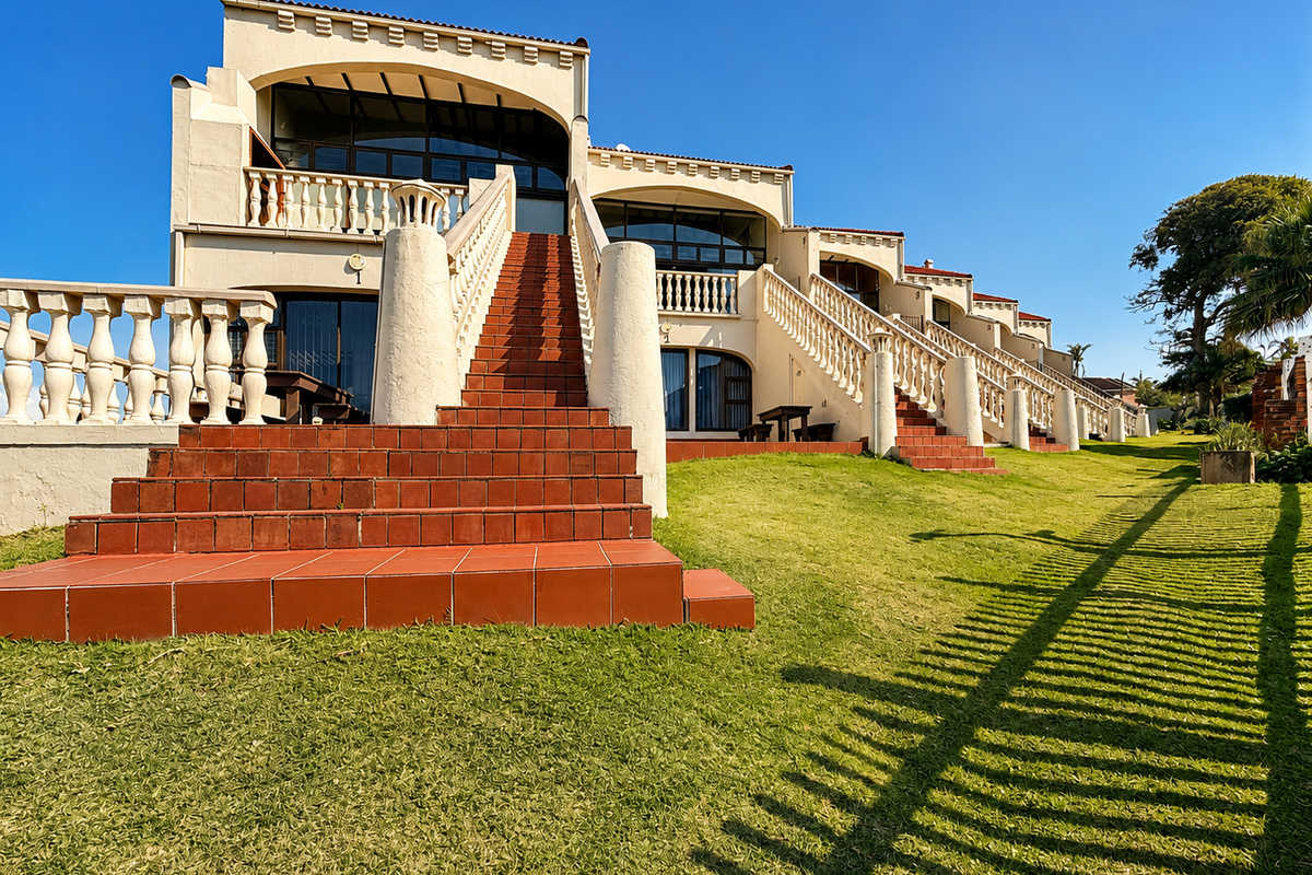 Rear view of a multi-level apartment complex featuring terracotta tiled staircases, classic balustrade railings, and direct access to a well-maintained lawn area.