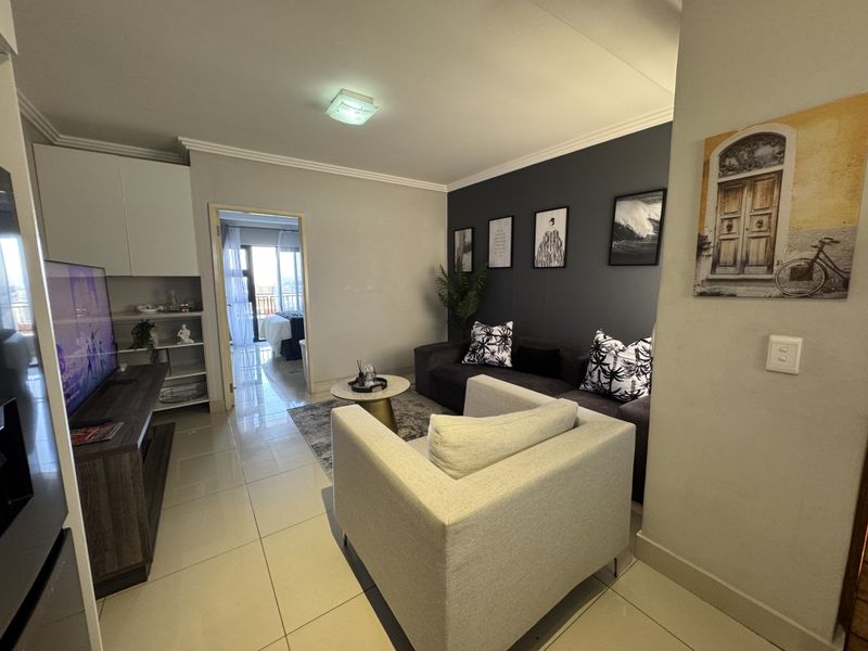 A well-maintained living room featuring tiled flooring, neutral wall tones, and built-in cabinetry, providing a functional and comfortable living space.