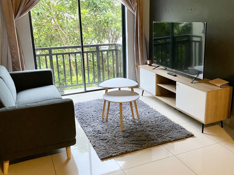 A bright living room featuring large sliding glass doors leading to a balcony, polished tile flooring, and a modern accent wall.