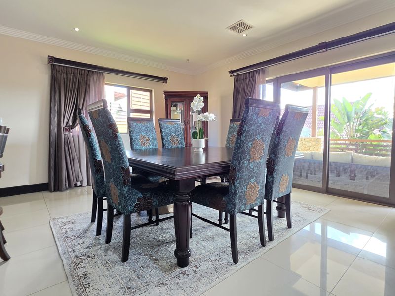 Spacious dining area featuring polished tiled flooring, recessed lighting, and large sliding glass doors providing seamless access to the outdoor patio.
